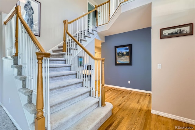 5305 W Lake Pl, Littleton, CO 80123 - staircase with a towering ceiling, baseboards, and wood finished floors