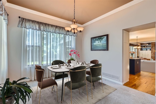 5305 W Lake Pl, Littleton, CO 80123 - dining area featuring a chandelier, light colored carpet, crown molding, and baseboards