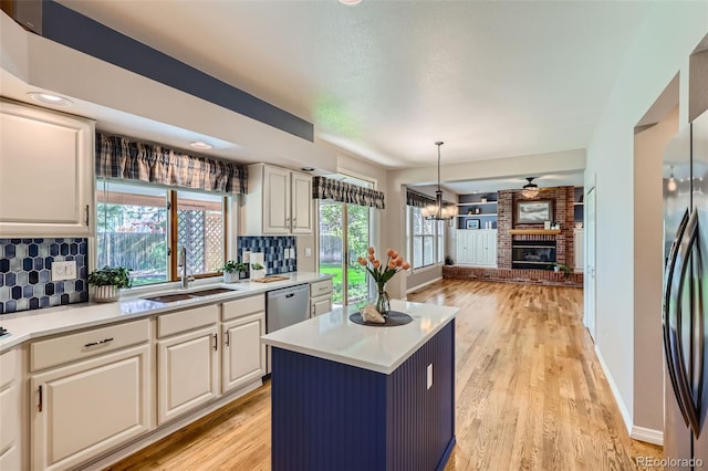 5305 W Lake Pl, Littleton, CO 80123 - kitchen featuring a sink, tasteful backsplash, light countertops, and light wood-style flooring