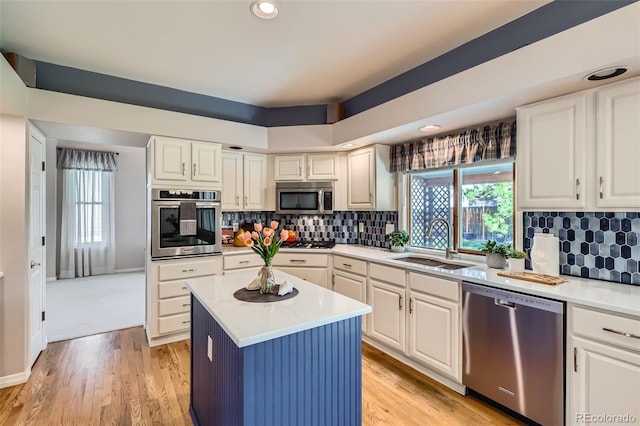 5305 W Lake Pl, Littleton, CO 80123 - kitchen with a sink, stainless steel appliances, a healthy amount of sunlight, white cabinets, and light countertops