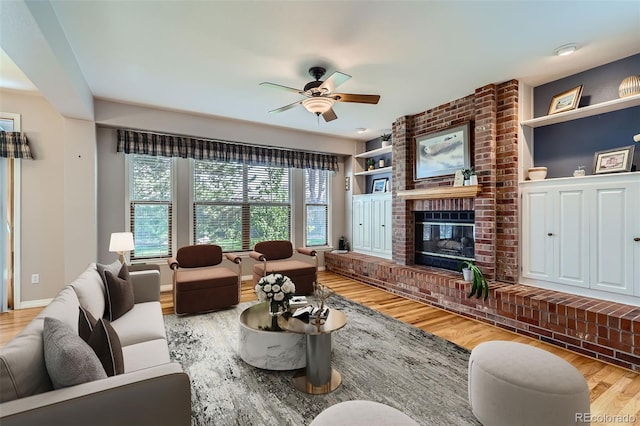 5305 W Lake Pl, Littleton, CO 80123 - living area featuring wood finished floors, a brick fireplace, a ceiling fan, built in shelves, and baseboards