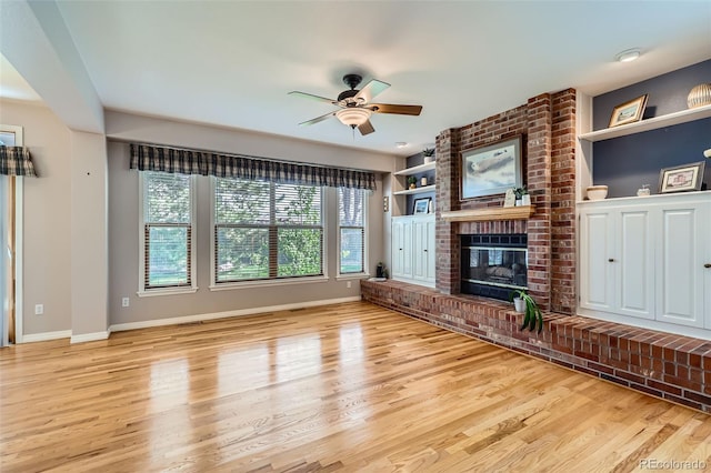 5305 W Lake Pl, Littleton, CO 80123 - unfurnished living room with wood finished floors, ceiling fan, a brick fireplace, and baseboards