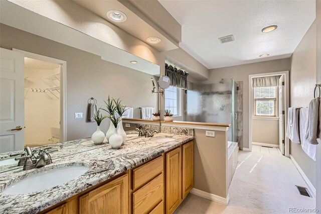 5305 W Lake Pl, Littleton, CO 80123 - full bathroom featuring a shower stall, double vanity, baseboards, and a spacious closet