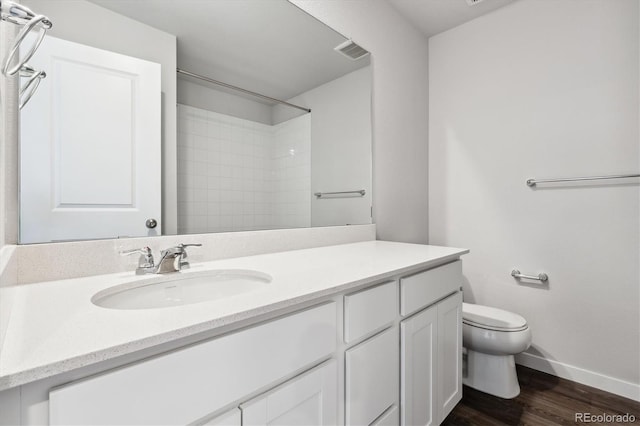 bathroom with vanity, a shower, toilet, and hardwood / wood-style flooring