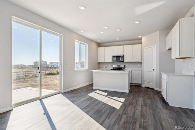 kitchen featuring sink, a kitchen island with sink, dark wood-type flooring, white cabinetry, and range with electric stovetop