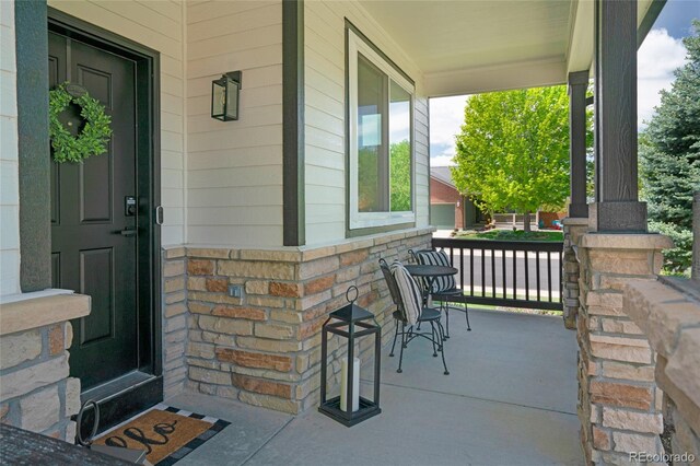 6488 Tilbury Ave, Firestone, CO 80504 - doorway to property featuring covered porch