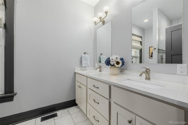 full bath featuring a sink, visible vents, double vanity, and tile patterned floors