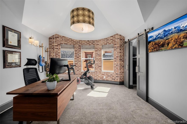 office space with brick wall, baseboards, a barn door, lofted ceiling, and carpet flooring