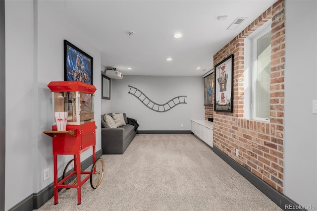 sitting room with visible vents, brick wall, baseboards, and carpet floors