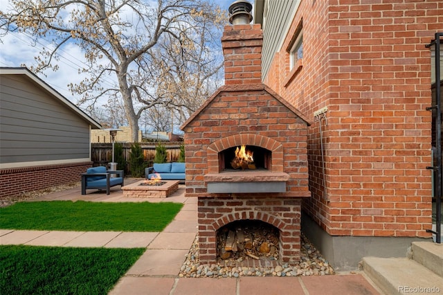 view of patio / terrace with fence and an outdoor brick fireplace