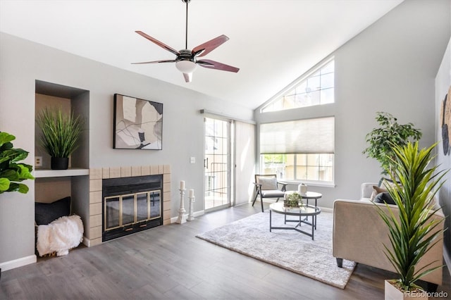 living room with ceiling fan, wood finished floors, baseboards, and a tile fireplace