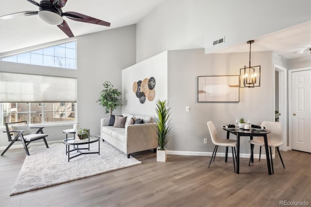 living room featuring visible vents, baseboards, and wood finished floors