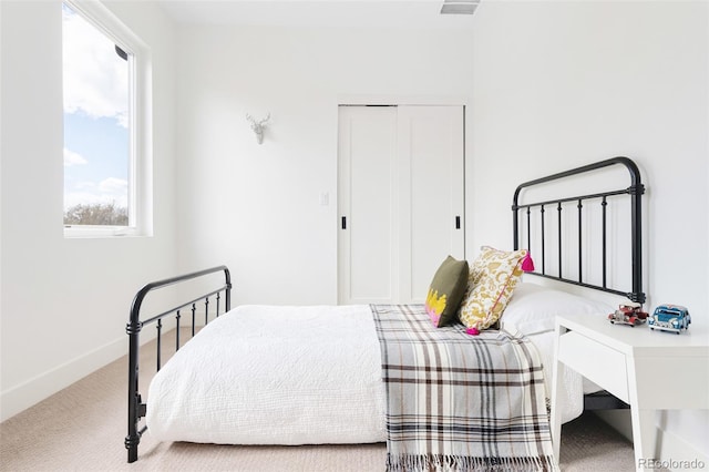 bedroom with carpet, a closet, and baseboards