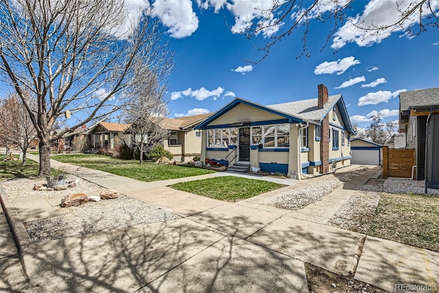 exterior space featuring a chimney, entry steps, an outdoor structure, a garage, and a lawn