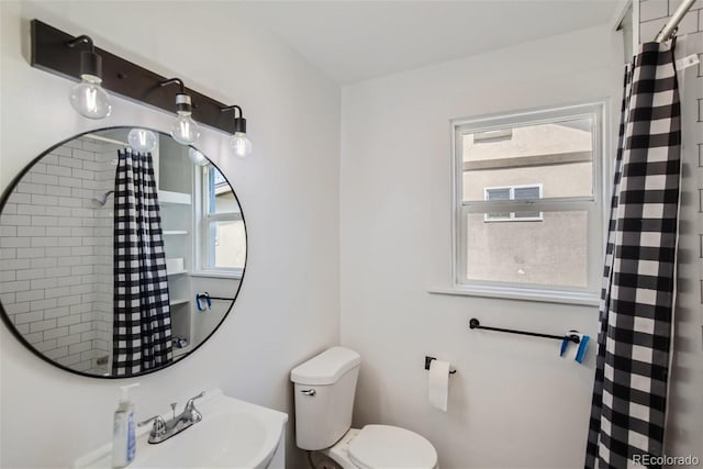 bathroom featuring a sink, toilet, and a shower with shower curtain