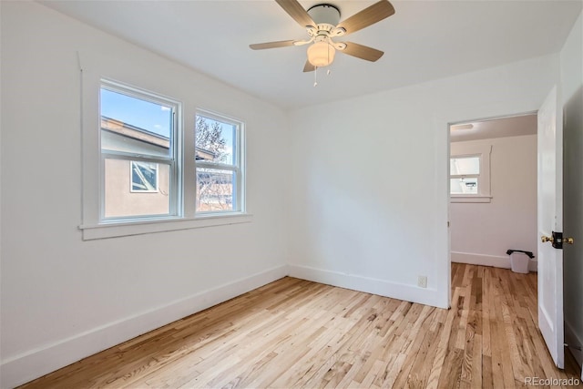 empty room with baseboards, light wood-style floors, and a ceiling fan