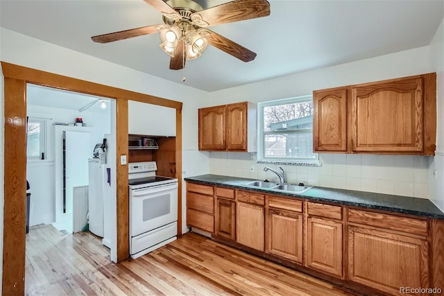 kitchen featuring brown cabinets, a sink, light wood-style floors, tasteful backsplash, and white range with electric stovetop