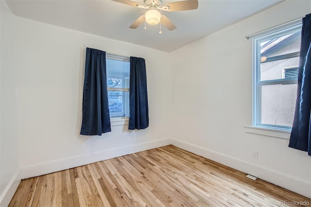 unfurnished room featuring baseboards, a ceiling fan, and light wood finished floors