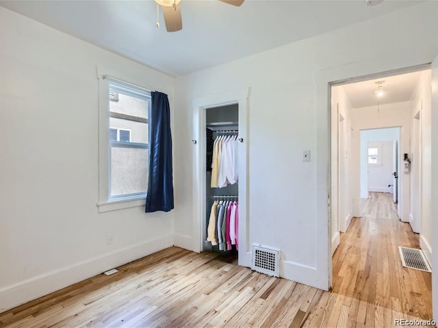 unfurnished bedroom featuring a closet, visible vents, baseboards, and light wood-style floors