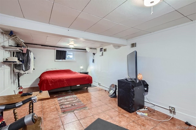 tiled bedroom with a paneled ceiling and visible vents