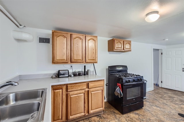 kitchen with light countertops, black range with gas cooktop, visible vents, and a sink