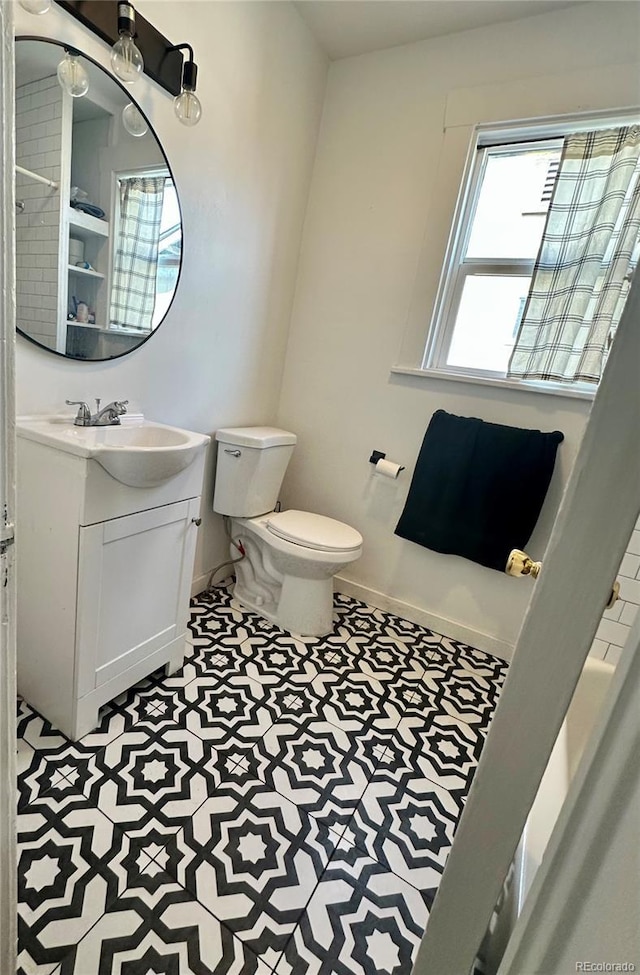 bathroom with vanity, toilet, and baseboards