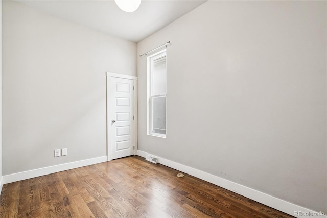 unfurnished room featuring a wealth of natural light and hardwood / wood-style floors