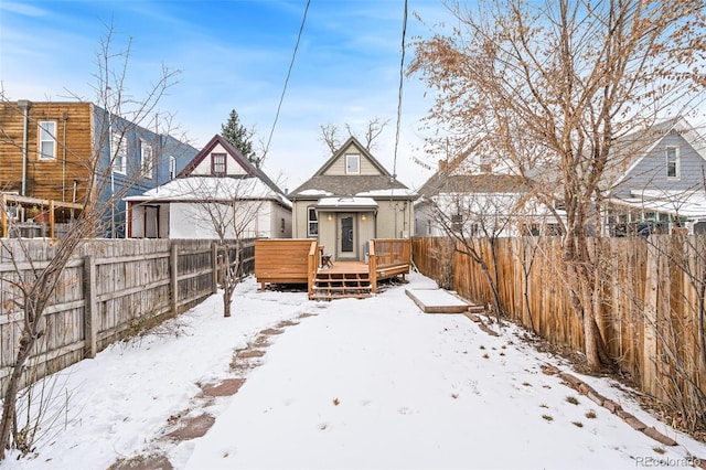 snow covered house with a wooden deck