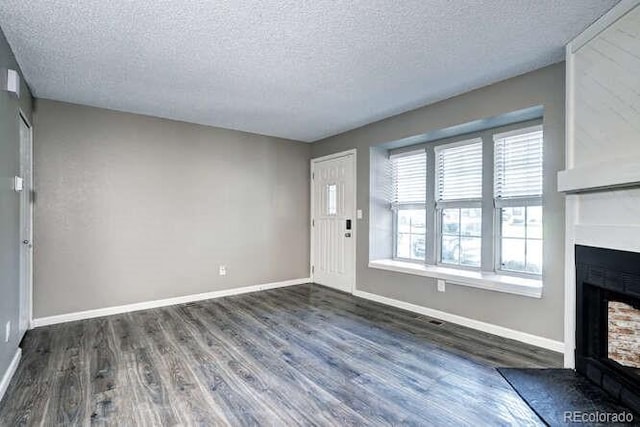 18131 E Arizona Ave Unit F, Aurora, CO 80017 - entrance foyer featuring a fireplace with flush hearth, dark wood-type flooring, and a textured ceiling