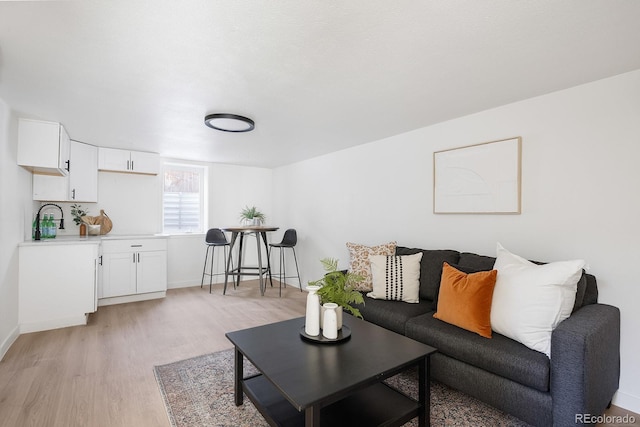 living area featuring light wood-style floors and baseboards