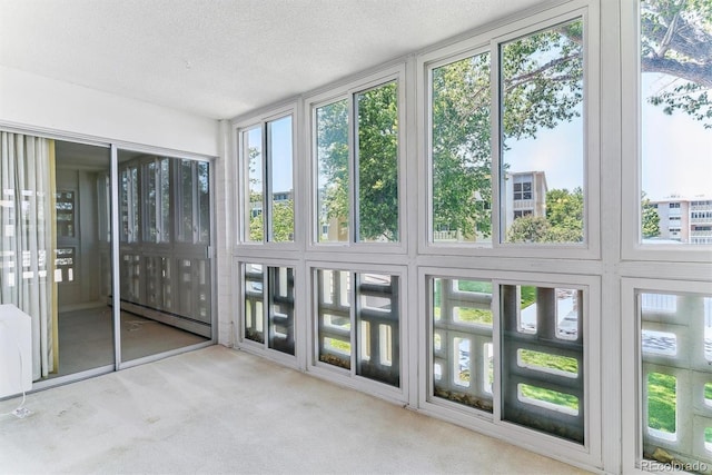620 S Alton Way Unit 5B, Denver, CO 80247 - unfurnished sunroom with baseboard heating, carpet flooring, healthy amount of natural light, and a textured ceiling