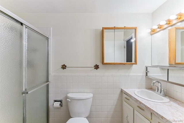 620 S Alton Way Unit 5B, Denver, CO 80247 - bathroom featuring tile walls, a stall shower, vanity, toilet, and a wainscoted wall