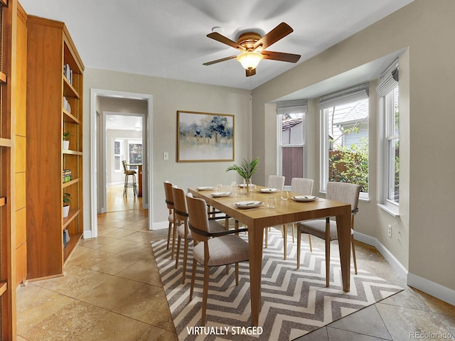 dining area with ceiling fan and baseboards