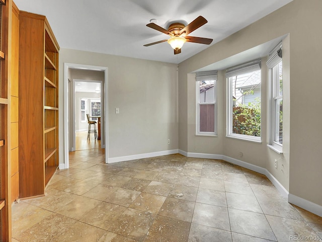 spare room featuring baseboards and a ceiling fan