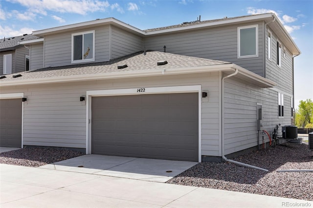 view of front of property featuring driveway and roof with shingles