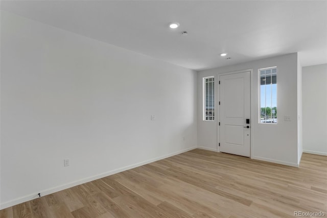 foyer entrance with light wood-style flooring, baseboards, and recessed lighting