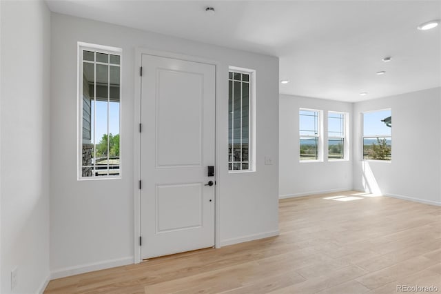 foyer entrance with light wood-style floors, recessed lighting, and baseboards