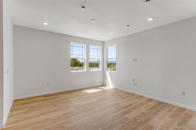 spare room with light wood-style flooring, baseboards, and recessed lighting