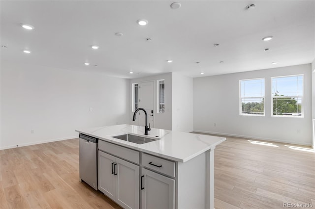 kitchen with a sink, dishwasher, open floor plan, light wood-style flooring, and recessed lighting