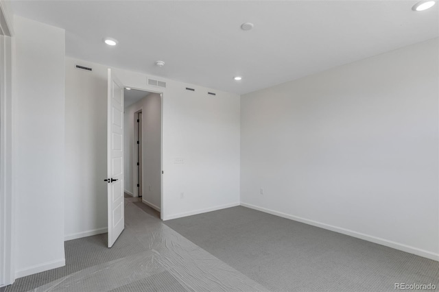 empty room with carpet floors, recessed lighting, and baseboards