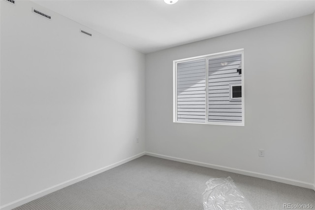 unfurnished room featuring carpet and baseboards