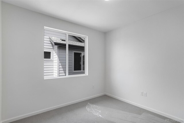 spare room with carpet and baseboards