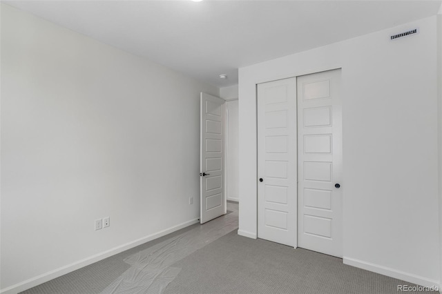 unfurnished bedroom featuring carpet, a closet, and baseboards