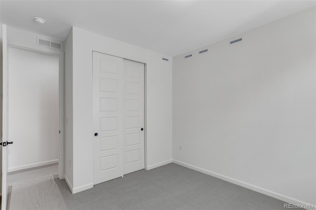 unfurnished bedroom with carpet, a closet, and baseboards