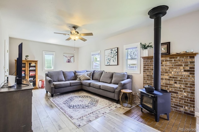 1065 6th St, Berthoud, CO 80513 - living room featuring a wood stove, a ceiling fan, and hardwood / wood-style floors