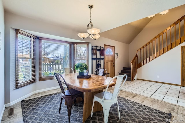 1065 6th St, Berthoud, CO 80513 - dining room featuring stairs, light wood finished floors, a chandelier, baseboards, and lofted ceiling