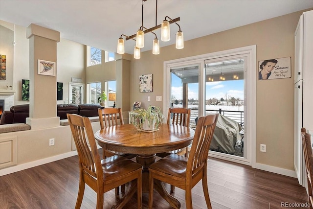 dining area featuring dark wood-type flooring and an inviting chandelier