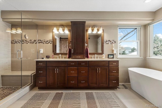 bathroom with vanity, tile patterned floors, independent shower and bath, and tile walls