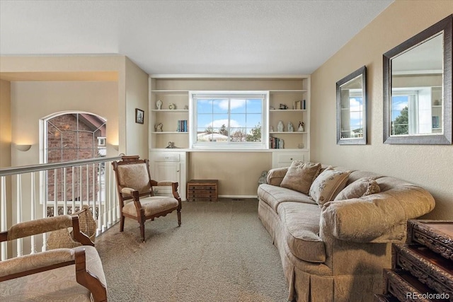 sitting room featuring built in features, a textured ceiling, and carpet flooring