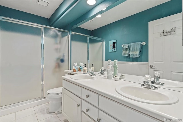 bathroom with tile patterned flooring, vanity, toilet, and walk in shower